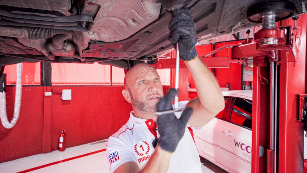 screwing the oil drain plug back for a Mercedes-Benz SLK 200