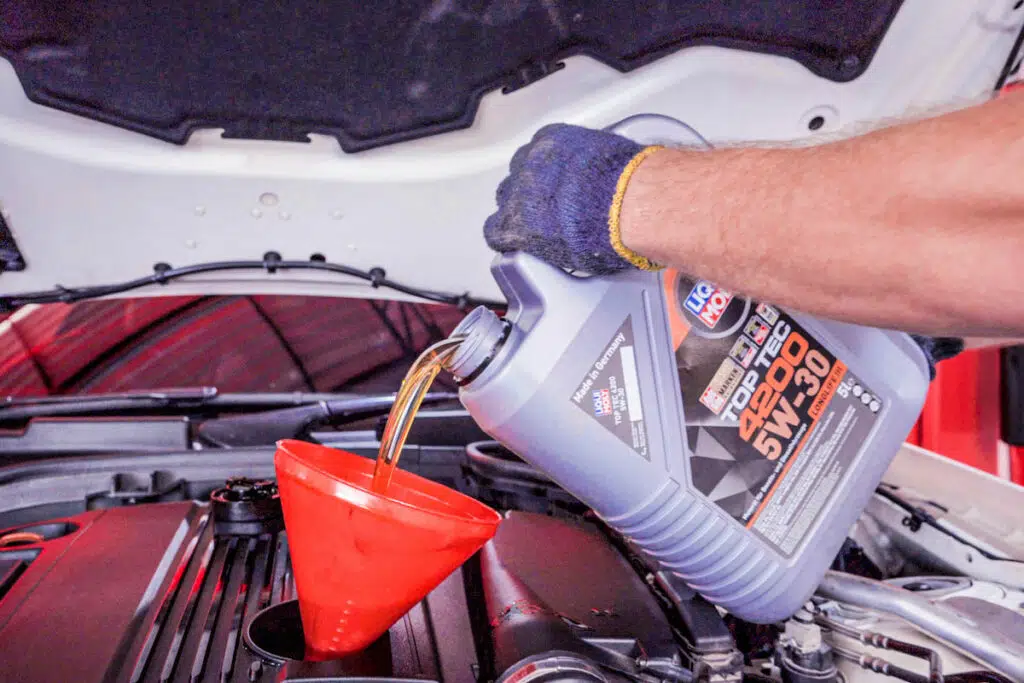 Pouring LIQUI MOLY oil into car