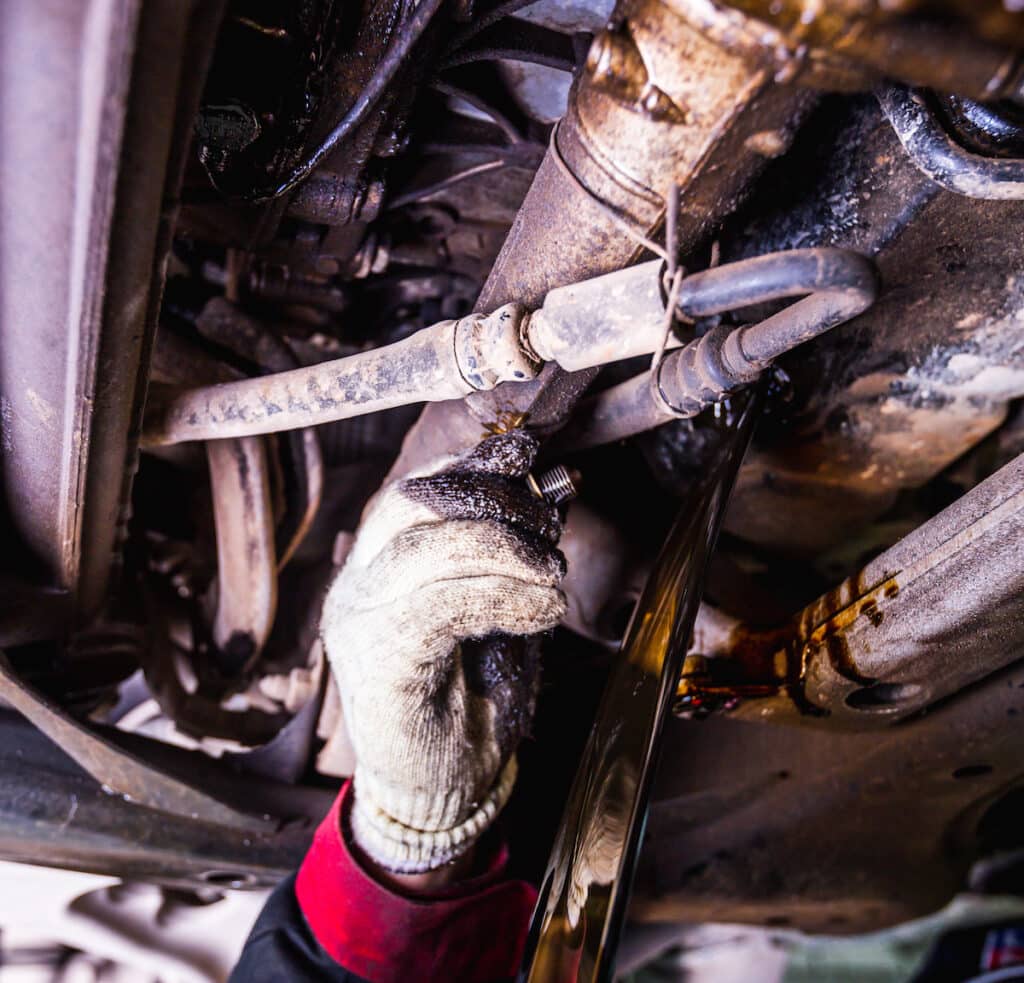 Unscrewing the oil drain plug by hand from Audi Q7