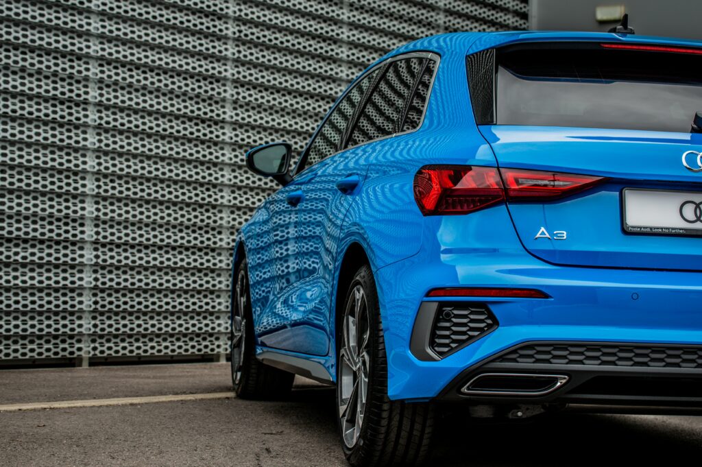 An Audi A3 outside a garage photographed from behind