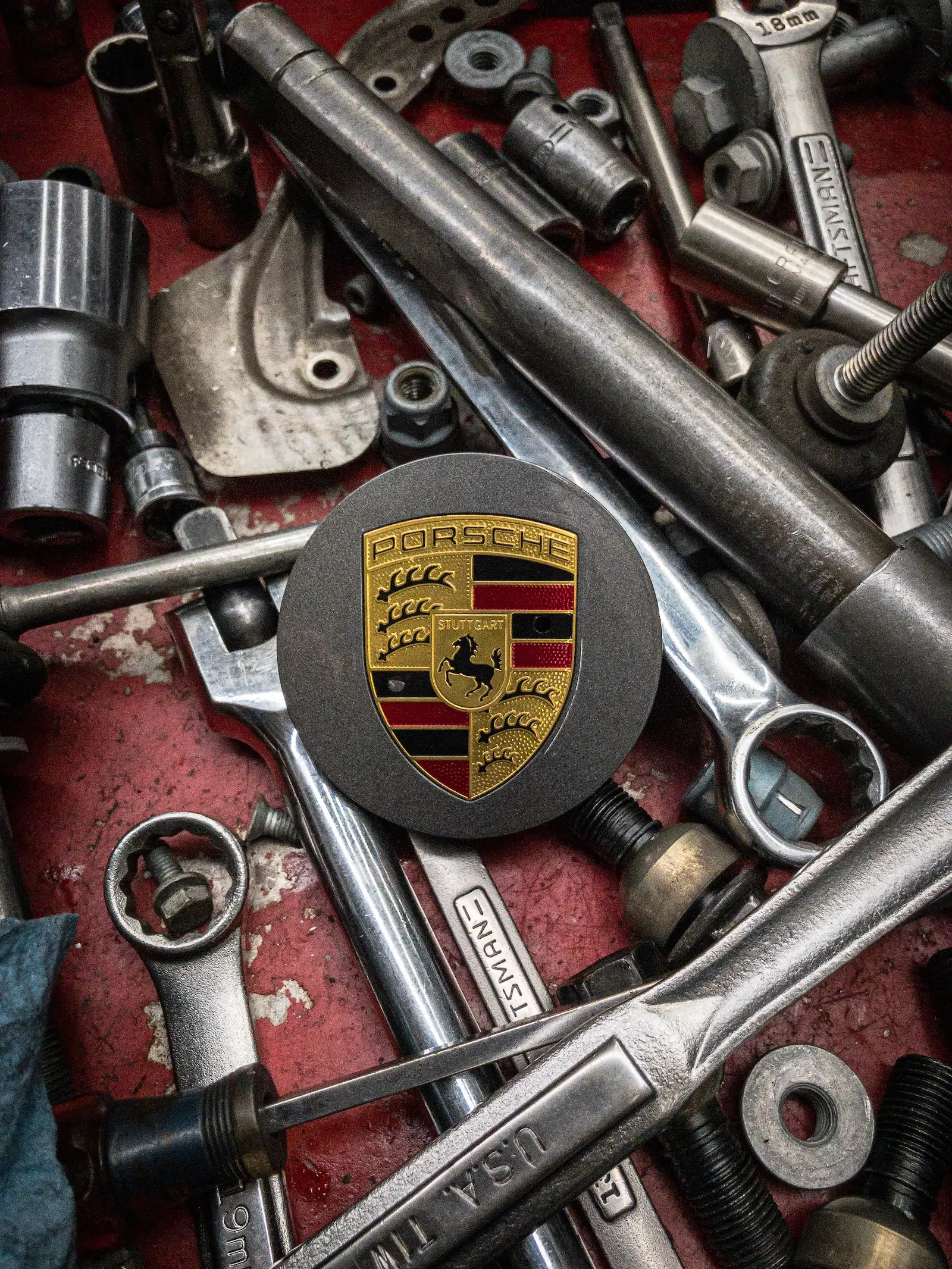 Porsche Badge with Porsche Service tools tools on a table