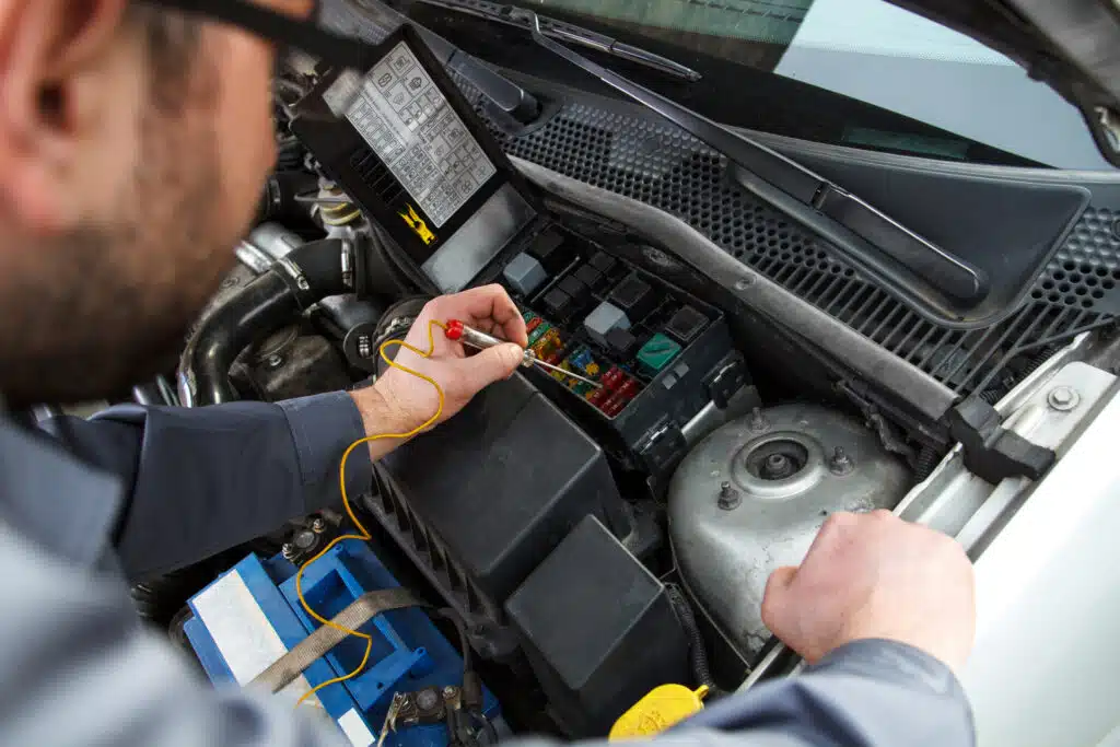 Mechanic checking car fuses