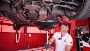A picture of a car engine with a hose draining the old automatic transmission fluid